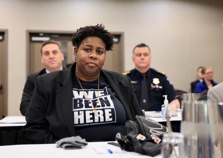 Kayla Borden sits in the Nova Scotia Police Review Board hearing. Behind her, Halifax Police Chief Dan Kinsella and city solicitor Andrew Gough can be seen. 