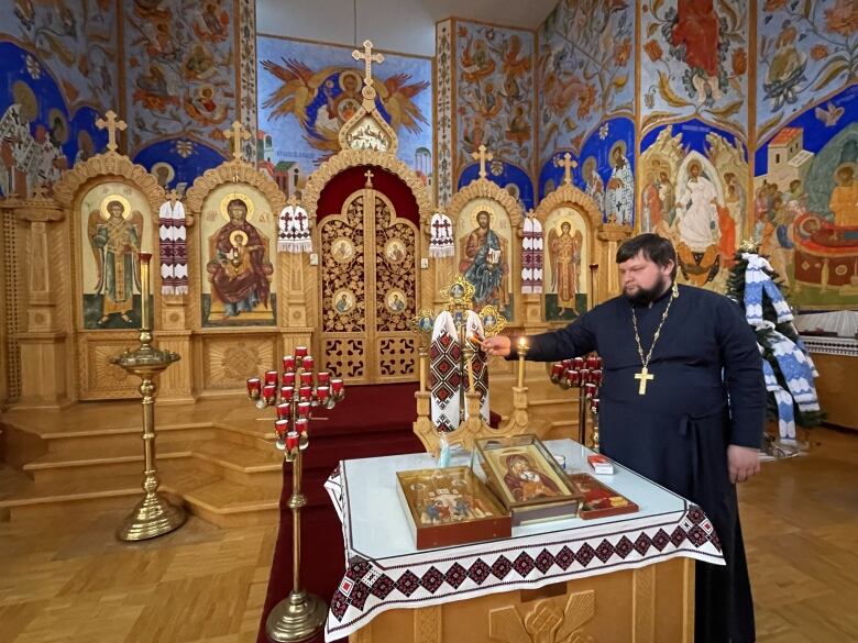 priest lighting candle 