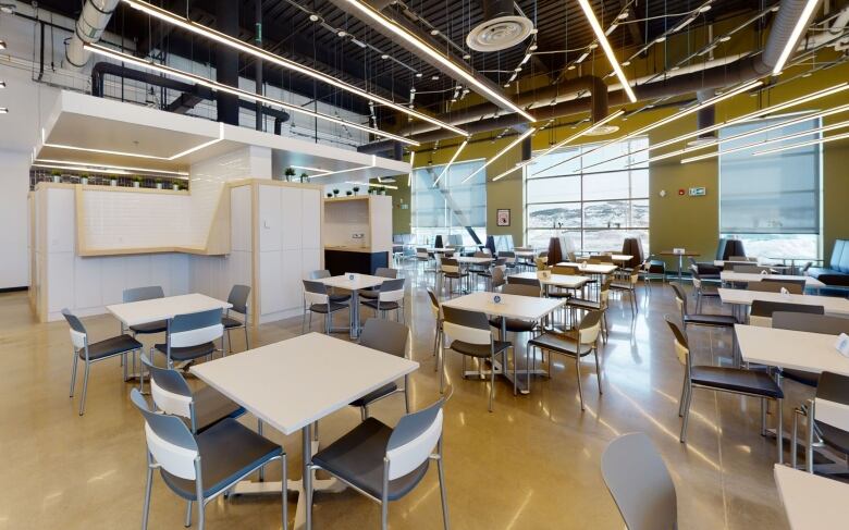 Chairs and tables inside a large, brightly lit room.