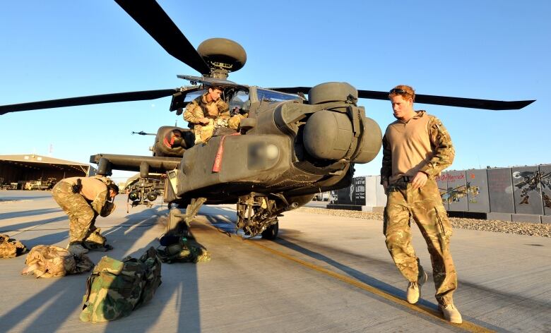 Soldiers inspect a helicopter.