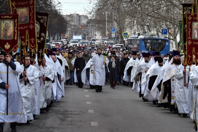 Russian Orthodox priests walk on the street.