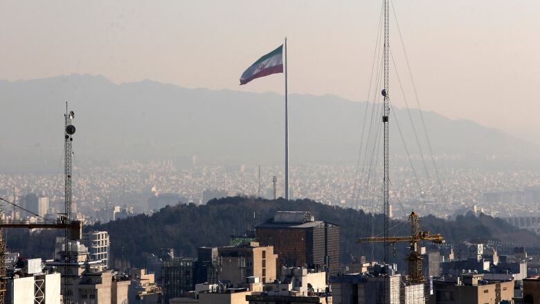 The Iranian flag is seen flying in Tehran.