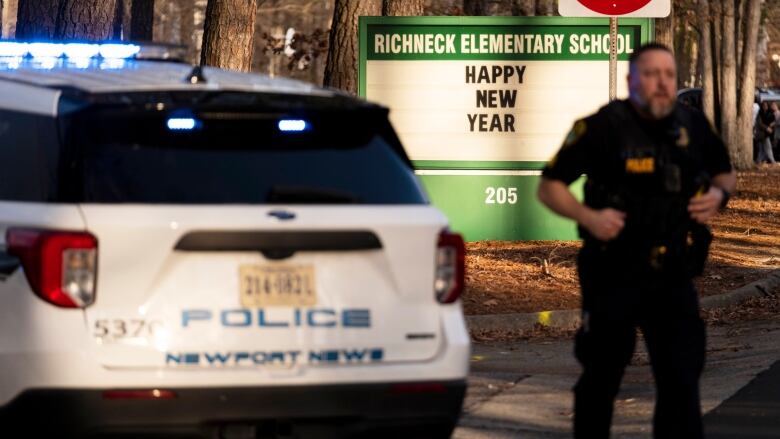 A police officer stands in front of an elementary school in Virginia where a teacher was shot on Friday.