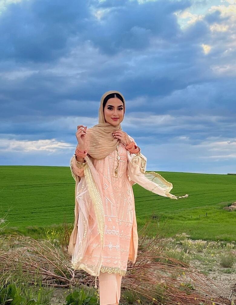 A woman wearing a headscarf if pictured standing in a feild