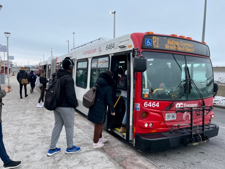 People board a red-and-white bus with R1 on the front screen.