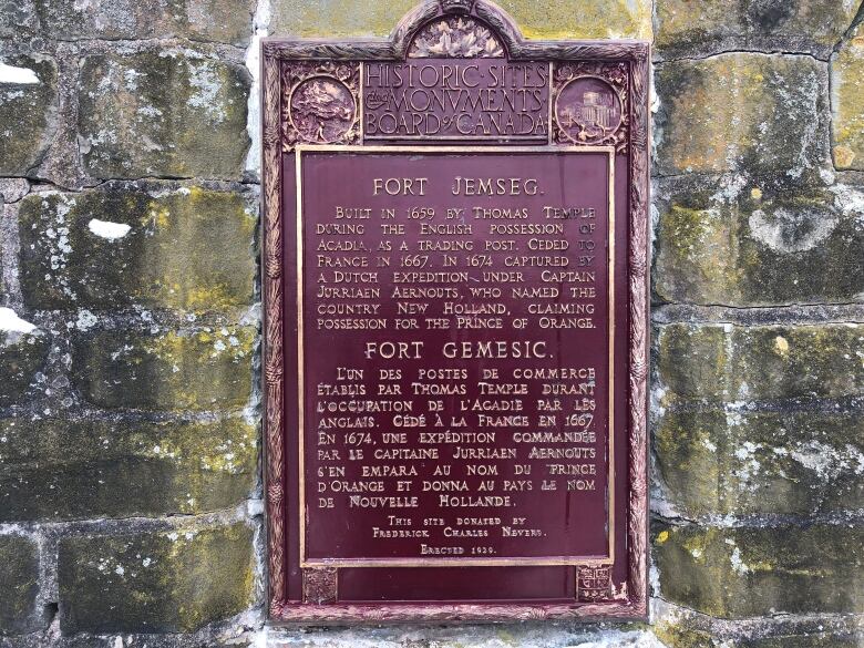 close up of old red plaque on stone monument