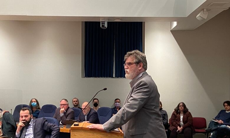 A man speaks while standing at a podium.