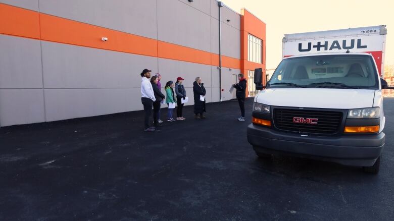 A U-Haul truck is parked outside a storage unit area. 