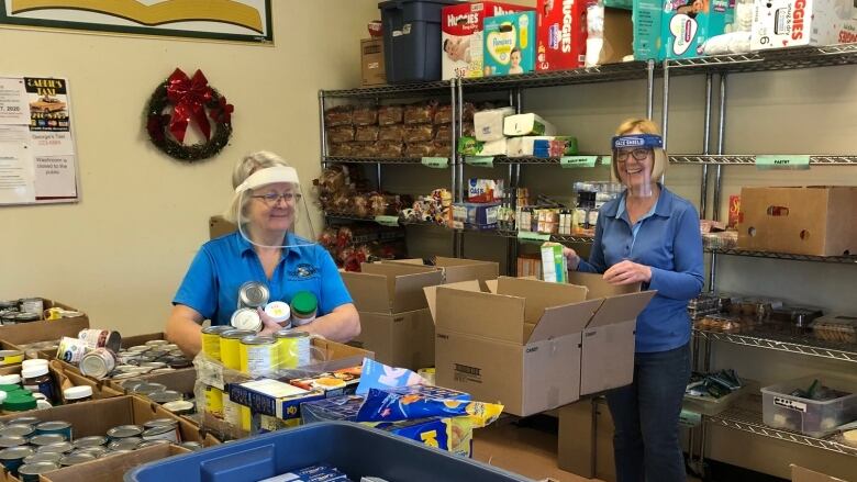 A photo of volunteers at the Dryden Food Bank sorting through boxes of food. Hampers are handed out weekly to clients in need.