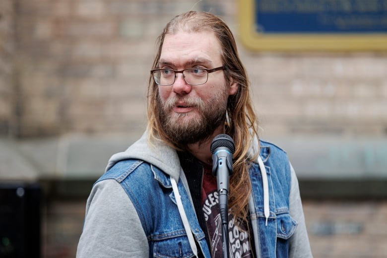 Gru, a Toronto advocate for the unhoused, speaks at a memorial outside Holy Trinity church in downtown Toronto on Jan. 10, 2023. Ken Lee, 59, who was identified as the victim of an alleged 'swarming' attack by teen girls, was added to the homeless deaths memorial.