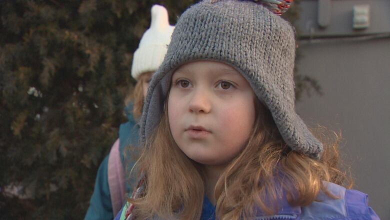 A little girl wearing a beanie. 