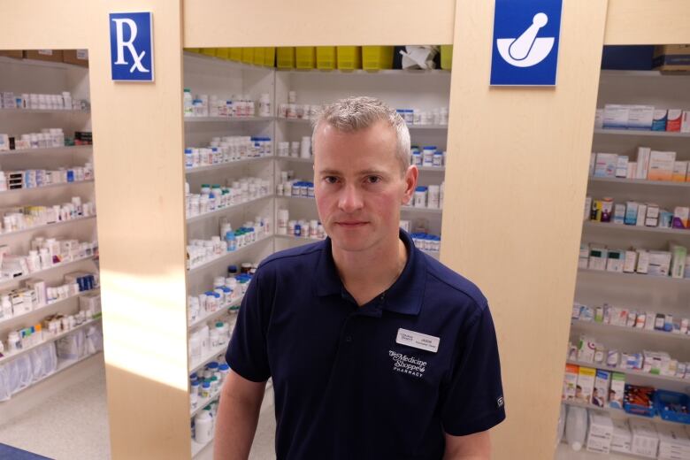 A man with short grey hair in a blue polo shirt that says 