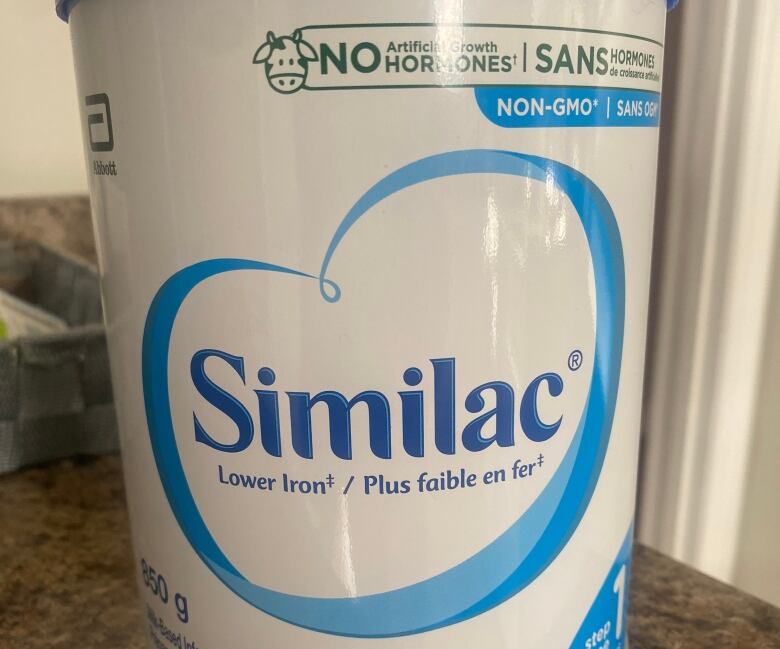 A jar of baby formula sits on a kitchen counter.