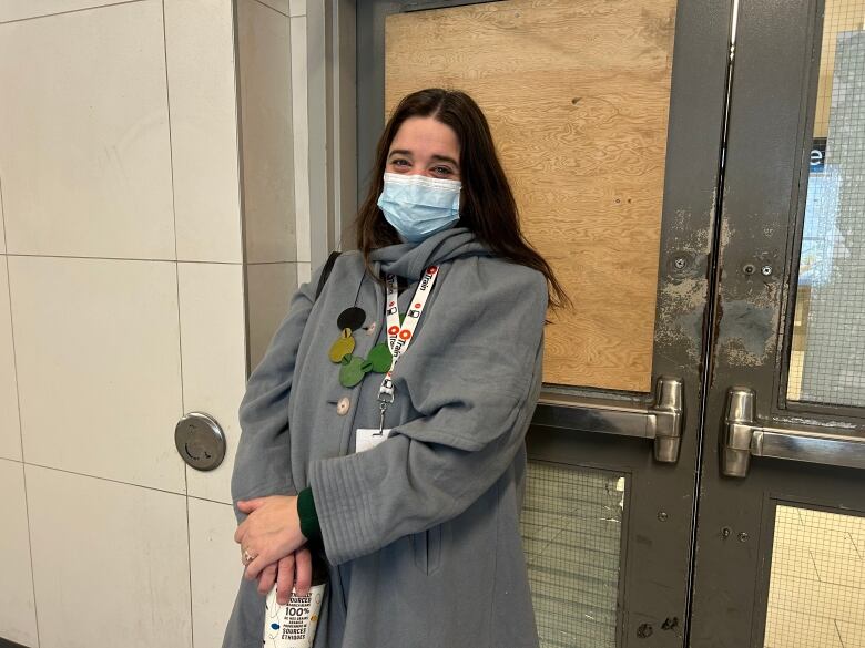 Alta Vista Coun. Marty Carr stands next to a damaged door at Rideau station on Jan. 12, 2023. The lower window is held together with tape while the upper window is replaced with a wood panel. 