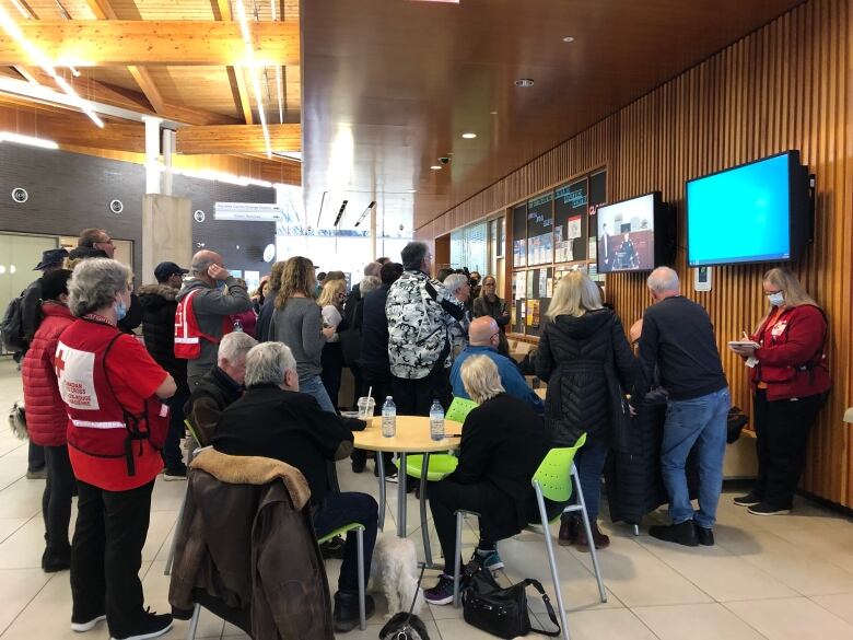 Evacuees and others at the St. Catherines Kiwanis Aquatic Centre listen as fire department Chief Dave Upper speak at a press conference.