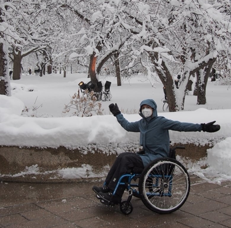 A woman in a wheelchair against a backdrop of snow.