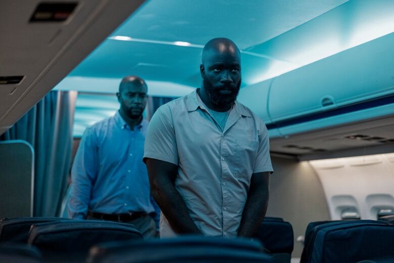 Mike Colter (right) plays a criminal being extradited in a scene from the film Plane. 