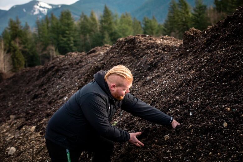 Simon Thorogood reaches into a pile of waste that has been screened for foreign materials.