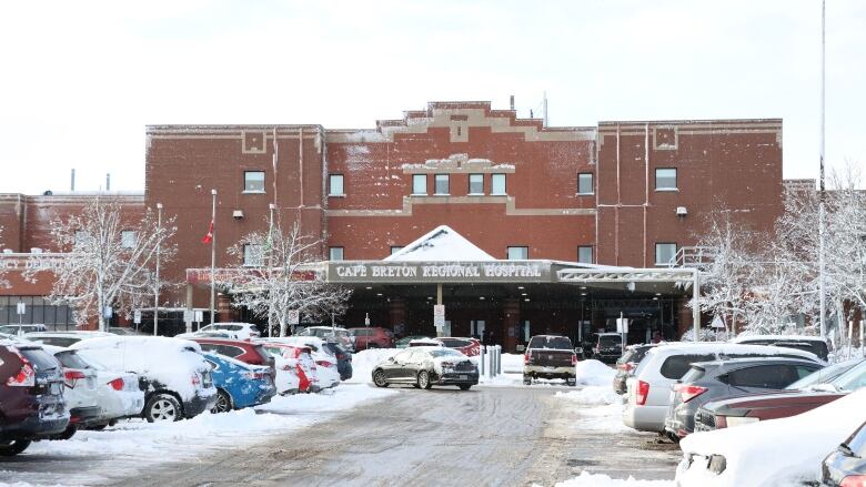 The front entrance of a large brick building is shown with a sign saying Cape Breton Regional Hospital.