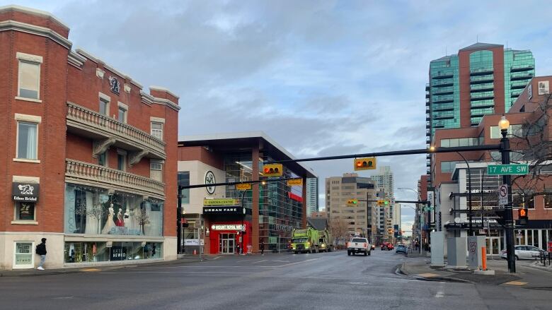 A stretch of road with buildings on either side. A large red brick building is in the foreground 