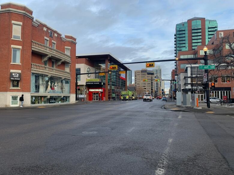 A stretch of road with buildings on either side. A large red brick building is in the foreground 