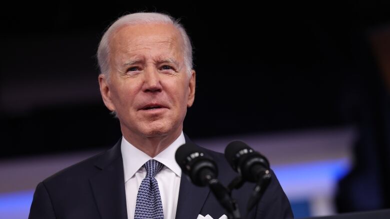 US President Joe Biden speaks at a podium with a microphone.