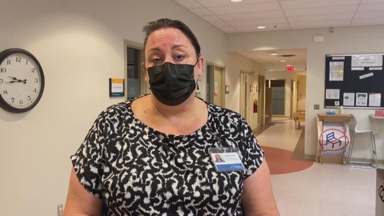 A woman in a clinic wearing a mask. 