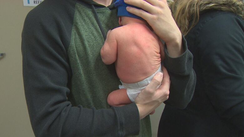 A man holds a baby. 