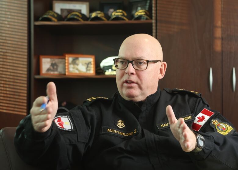 A man in a military uniform gestures as he speaks.