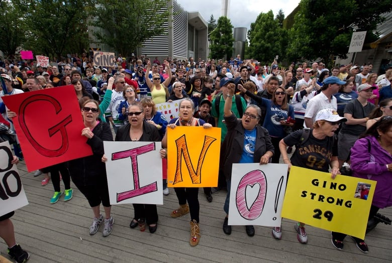 Hundreds of fans cheer in support of Vancouver Canucks' enforcer Gino Odjick outside Vancouver General Hospital.