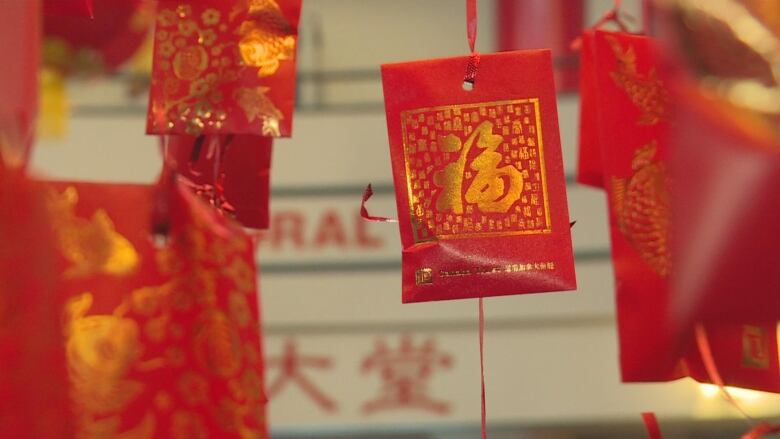 a red envelope floating in the air with gold Chinese writing.