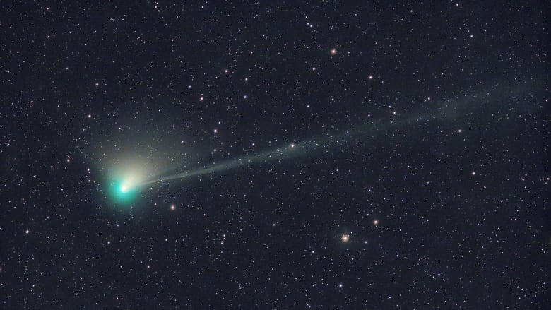 A green comet is shown, with a long wispy tail.