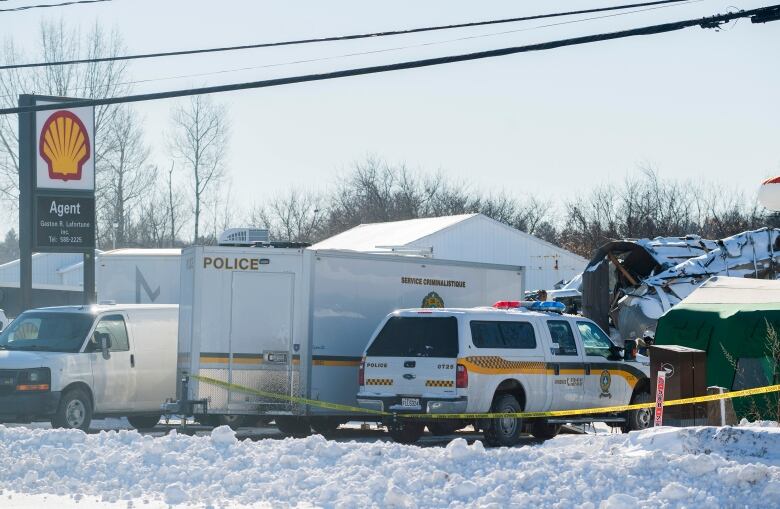 Police vehicles parked near debris 