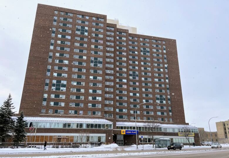 A large brick building stands in the middle of the photo, in brown brick with hundreds of windows.