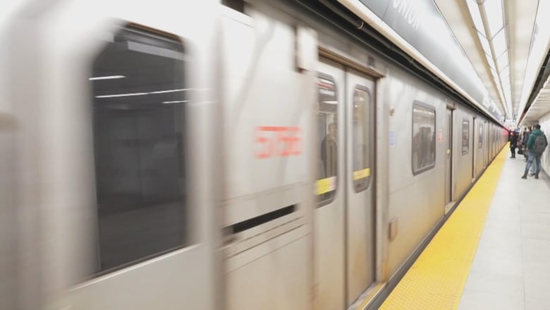 A picture of a moving subway can be seen, with passengers waiting to go on board in the background.