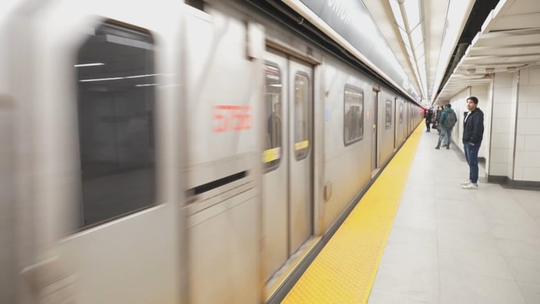 A picture of a moving subway can be seen, with passengers waiting to go on board in the background.