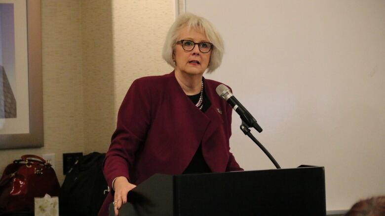 Woman speaking at a podium.