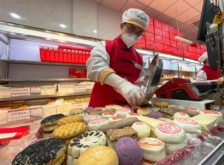 A shop worker packs a box of traditional pastries at a bakery in Beijing.