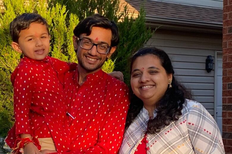 Three people stand for a photo.