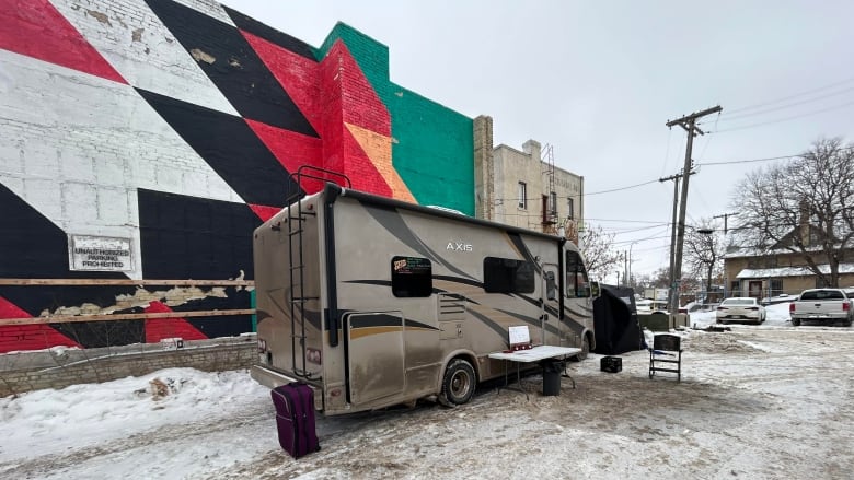 An RV is parked in a snow-covered parking lot.