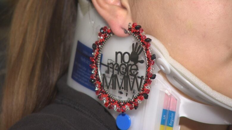 A beaded earring says 