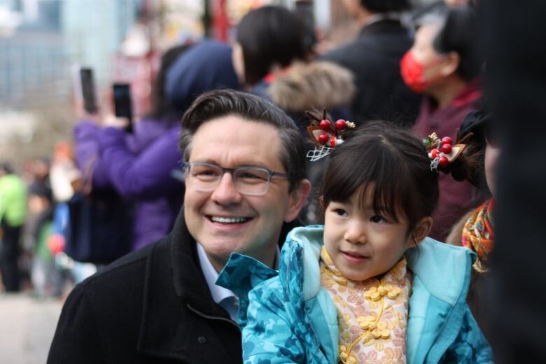 A politician poses with a child for a photo.