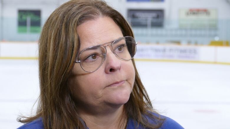 Manitoba Premier Heather Stefanson looks ahead. She is standing inside a hockey arena.