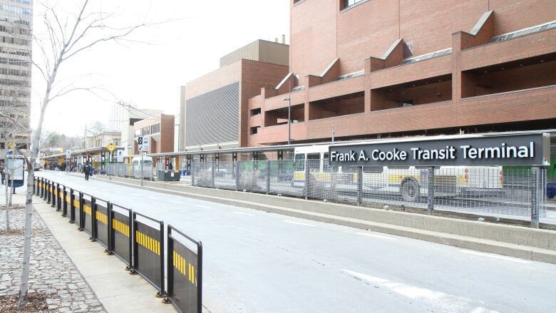 A sign of Frank A. Cooke Transit Terminal with an HSR bus behind it.