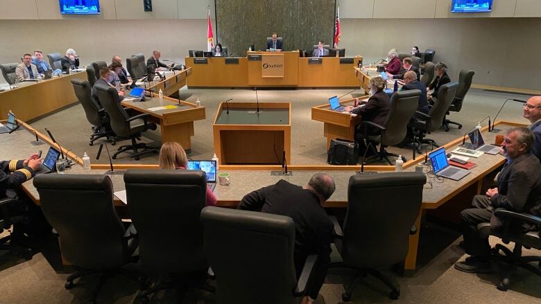 Councillors sit inside the city council chambers