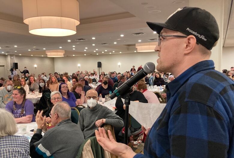 A man speaking in front of a crowd