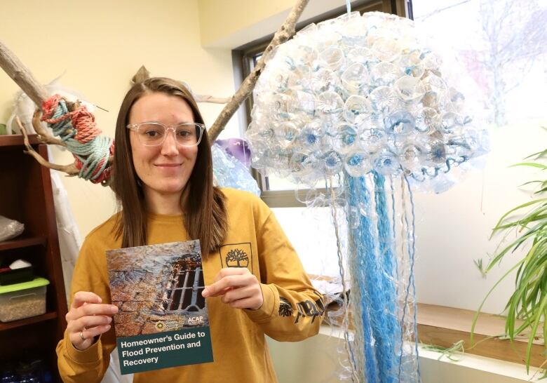 A woman holds a homeowner's guide to flood prevention and recovery that is handed out by the Cape Breton Regional Municipality. 