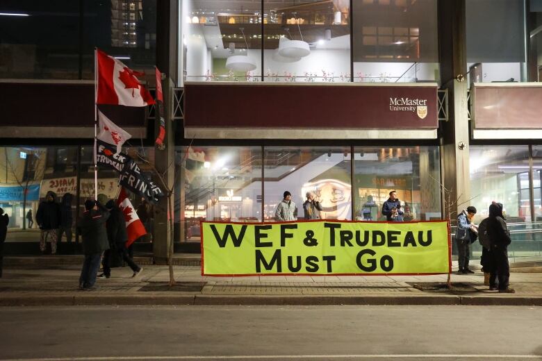 Protesters in Hamilton display a banner that says 