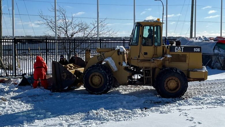 Some belongings and debris at the Charlottetown Event Grounds encampment is carried away in a front-end loader.