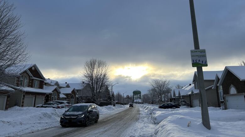 Cars drive down Lloydalex Crescent in Stittsville on Jan. 23, 2023. Neighbours along the street say cars regularly speed and ignore stop signs. 